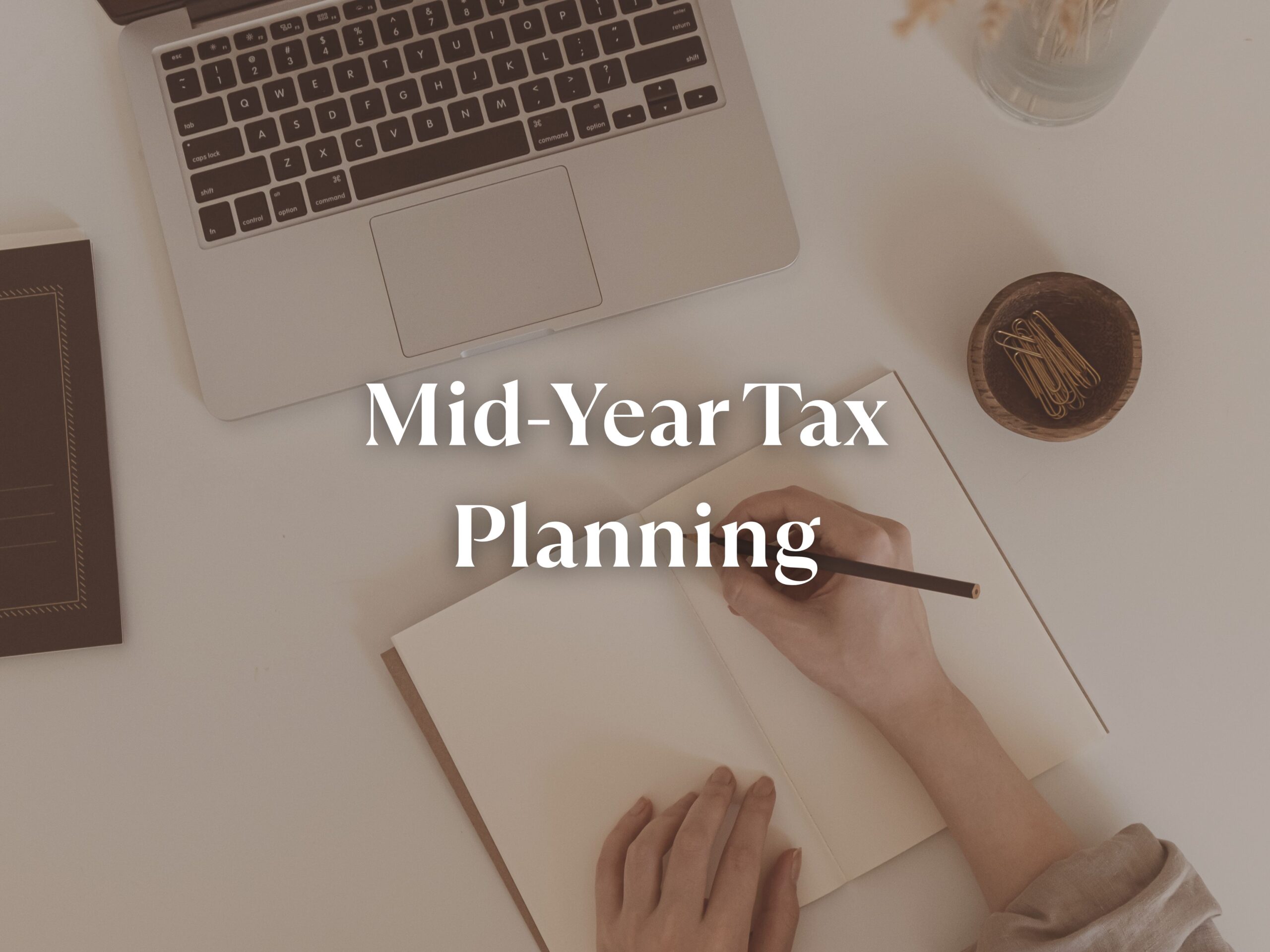 "Person writing at a desk with the words 'Mid-Year Tax Planning' — representing small business financial planning, bookkeeping review, and estimated tax strategies with C Squared Accounting."